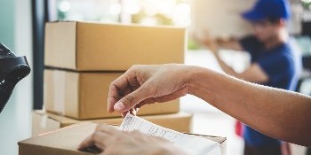 Worker placing shipping label on box